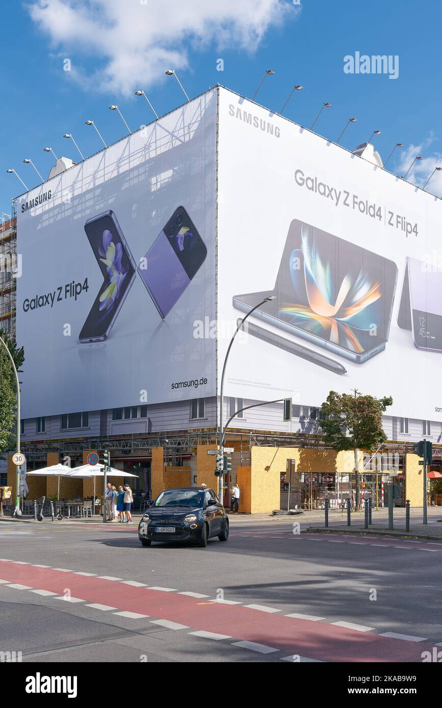 Straßenszene in der Kantstraße in Berlin. Im Hintergrund auf einer Baustelle Werbung für ein Smartphone. Stockfoto