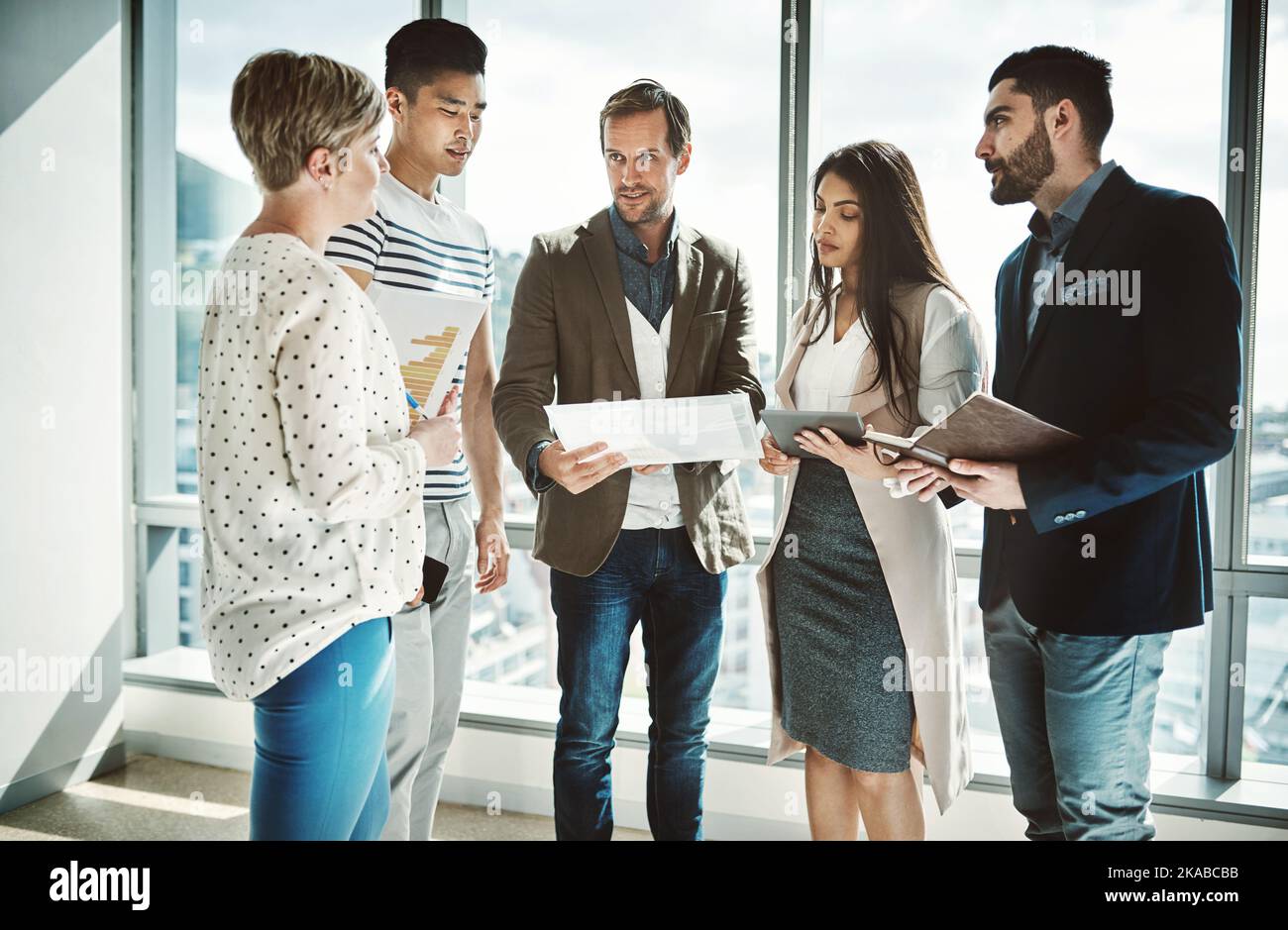 Bitte teilen Sie uns Ihre Ideen mit. Eine Gruppe fokussierter Geschäftsleute, die tagsüber im Büro an Ideen arbeiten. Stockfoto