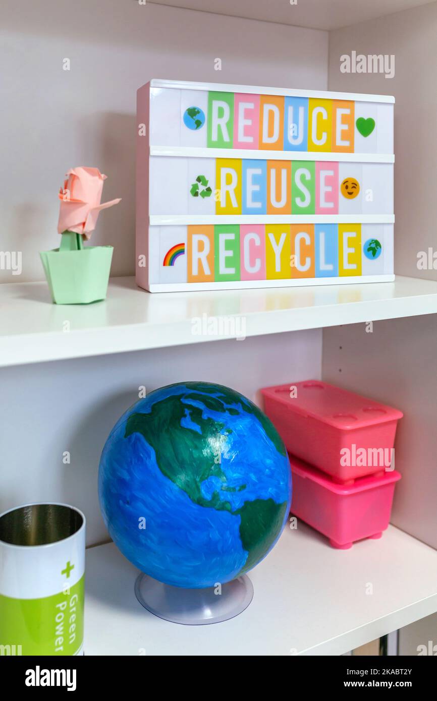 Lightbox mit Text Reduzieren, wiederverwenden, recyceln und Erdkugel im Regal im Klassenzimmer Stockfoto