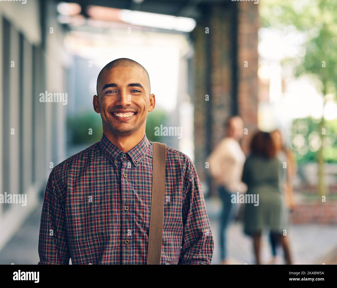 Ich Stelle meine Ausbildung an die erste Stelle. Porträt eines glücklichen jungen Mannes, der draußen auf dem Campus steht. Stockfoto