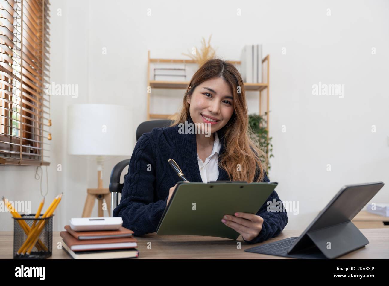Junge attraktive Geschäft asiatische Frau spricht über Verkauf Bericht in Videokonferenz auf Tablet Online-Meeting in der Arbeit von zu Hause aus, arbeiten Stockfoto