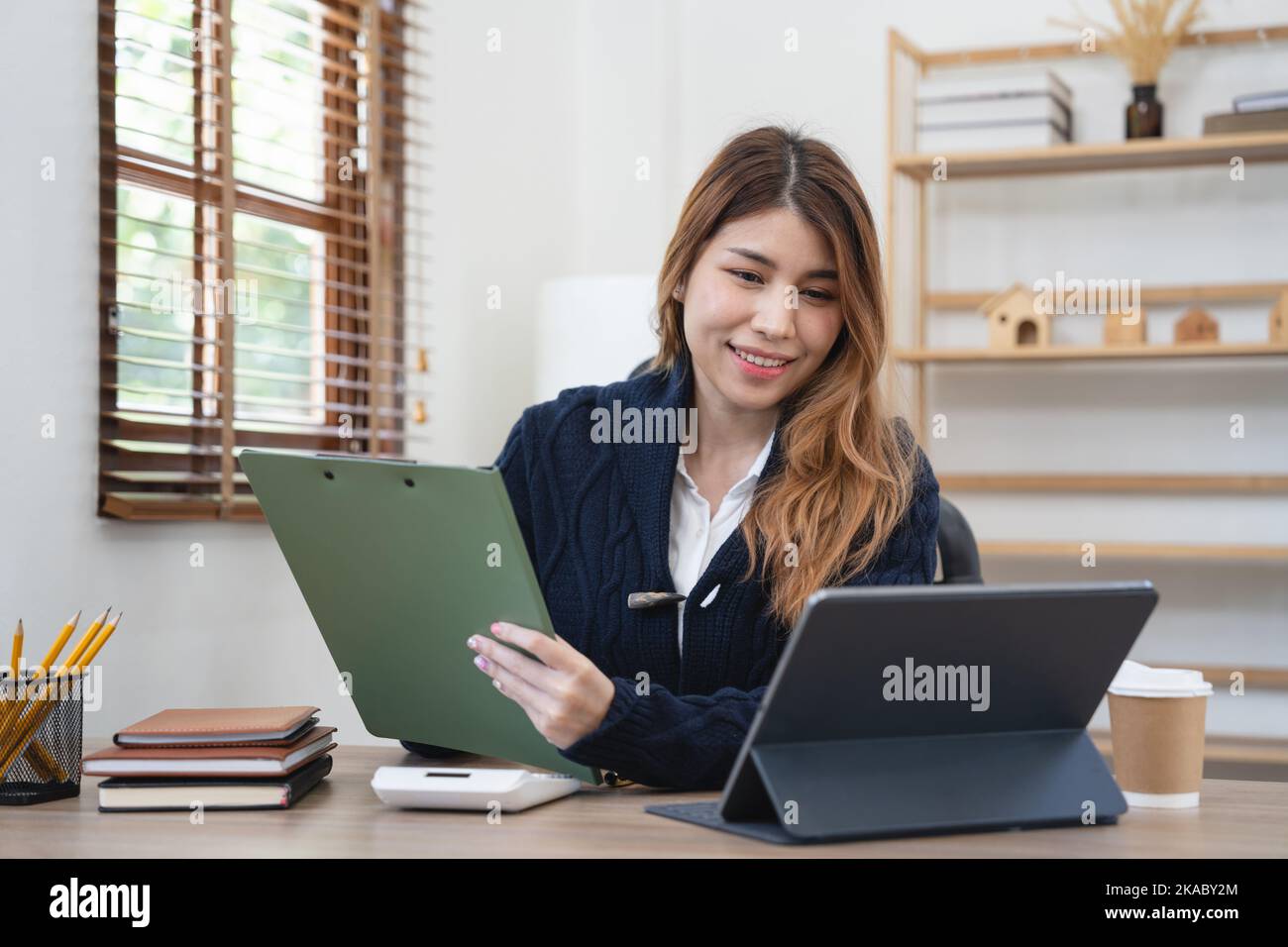 Junge attraktive Geschäft asiatische Frau spricht über Verkauf Bericht in Videokonferenz auf Tablet Online-Meeting in der Arbeit von zu Hause aus, arbeiten Stockfoto