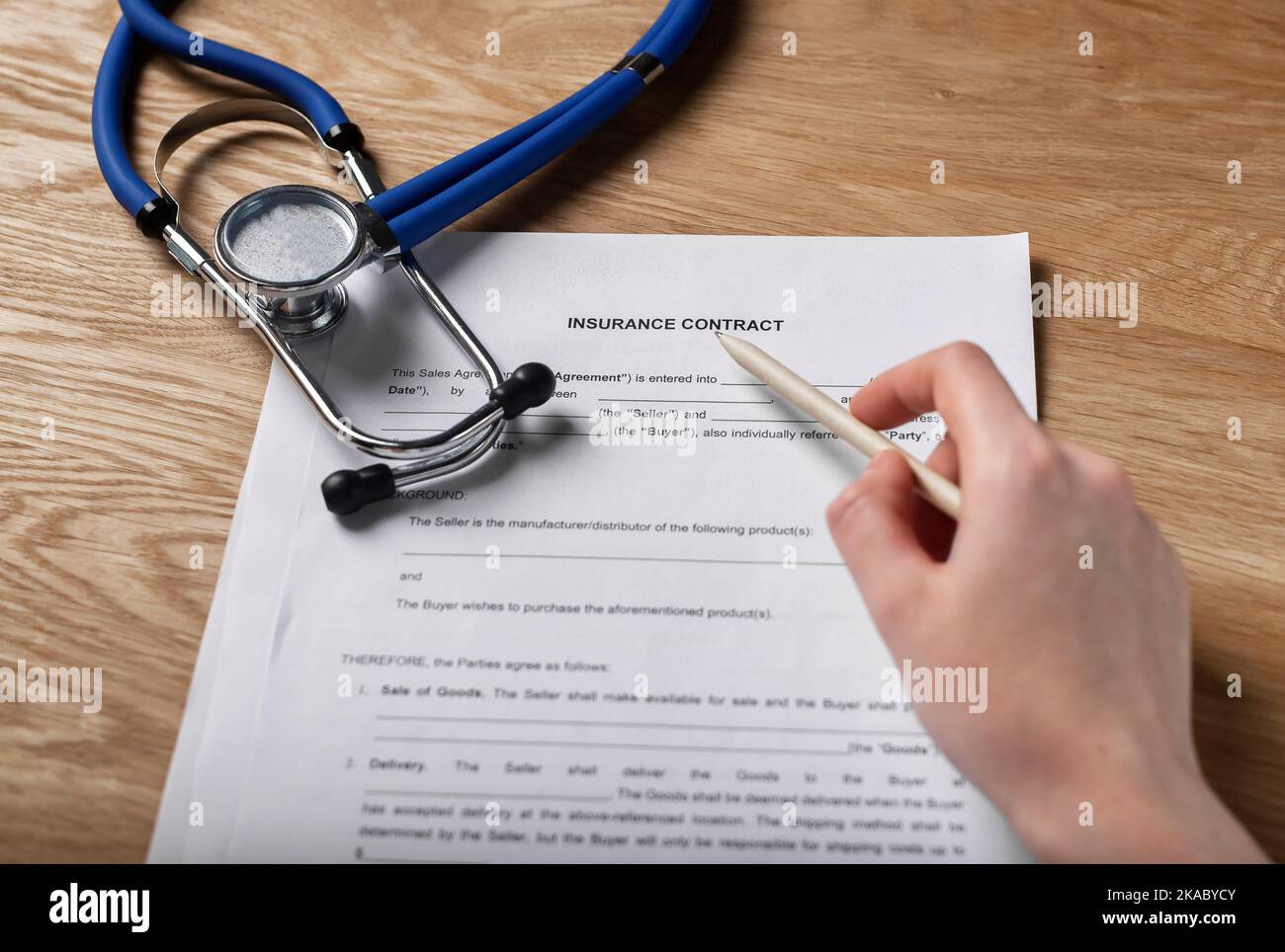Krankenversicherung, Vertrag und Stethoskop für Versicherte, Hand mit Stift. Stockfoto