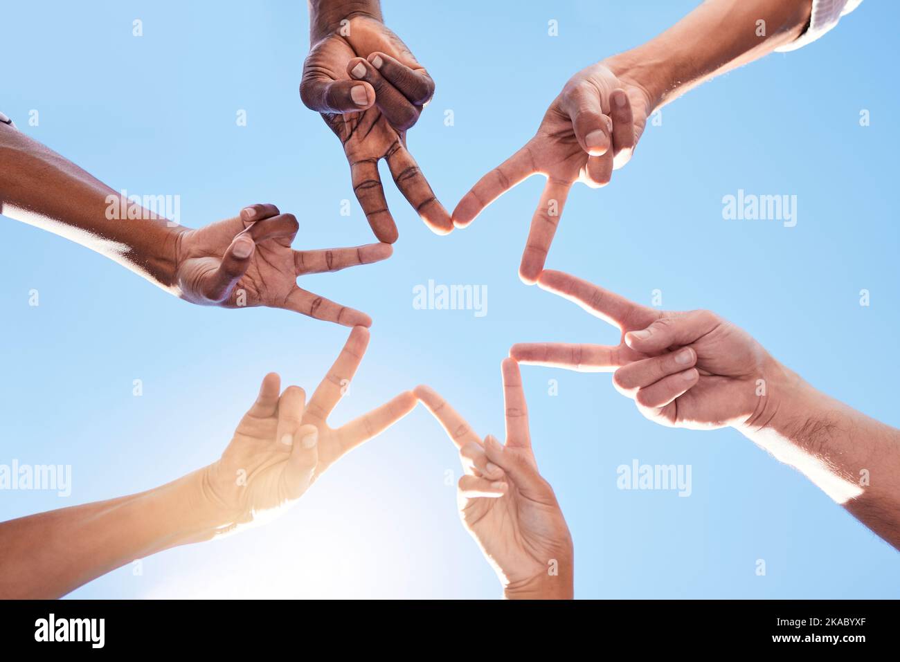 Star, Hände und Team, Solidarität und Frieden mit Vielfalt und Gemeinschaftszusammenarbeit mit blauem Himmel und Sonne. Teambildung, gemeinsam und in Gruppen mit Stockfoto