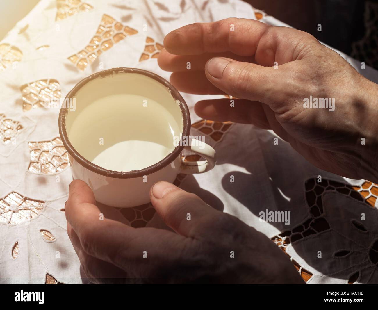 Weibliche Hände nach harter Arbeit nehmen Metall weißen Becher mit Wasser. Stockfoto