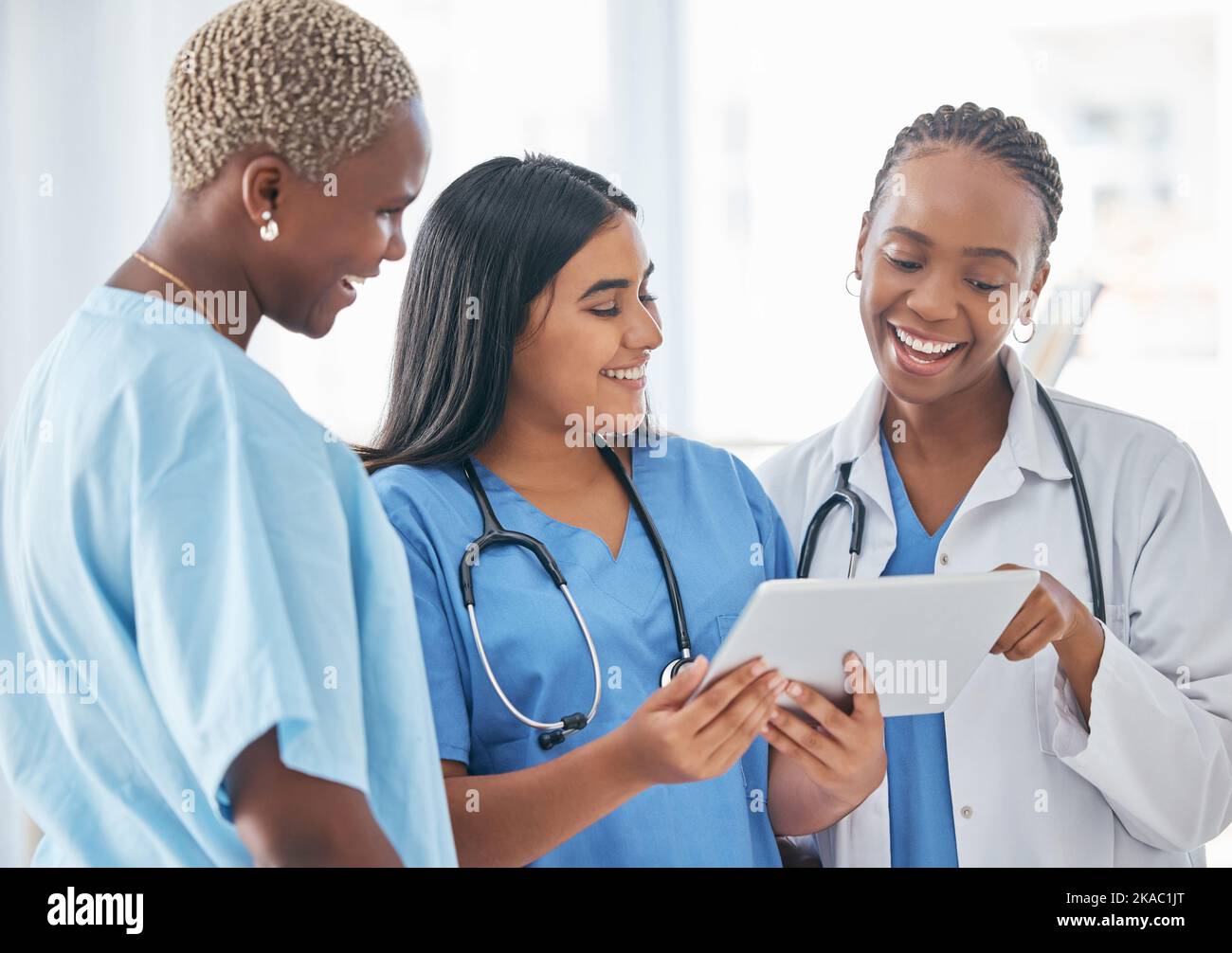 Arzt, Team und Tablet in Zusammenarbeit mit Smile für Forschung, Gesundheitsversorgung oder gute Nachrichten im Krankenhaus. Fröhliche medizinische Fachkräfte lächeln ein Stockfoto