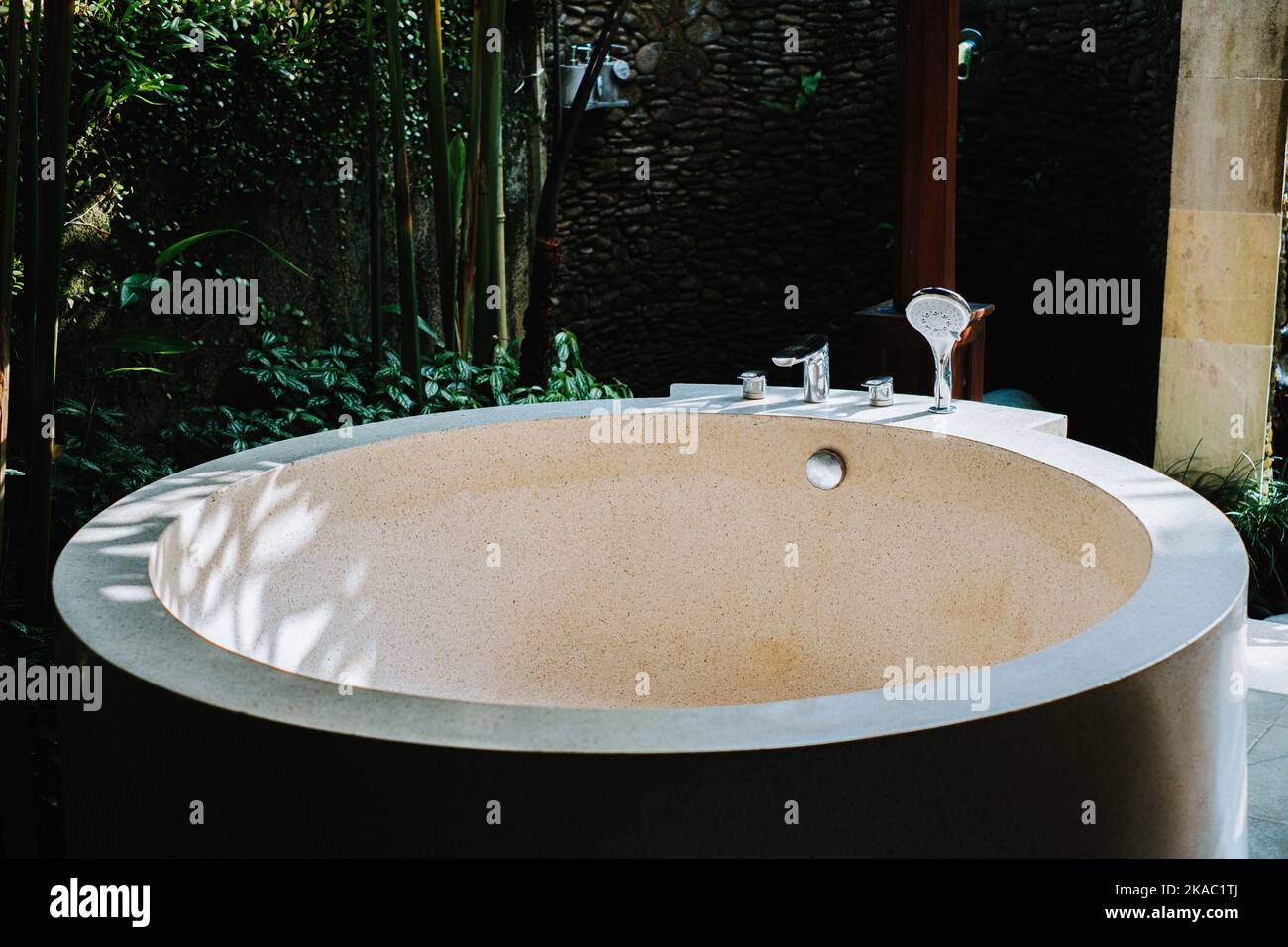 Abgerundete Badewanne aus Beton mit Terrazzo-Finish. Es wird in einer Villa in Ubud, Bali, verwendet Stockfoto