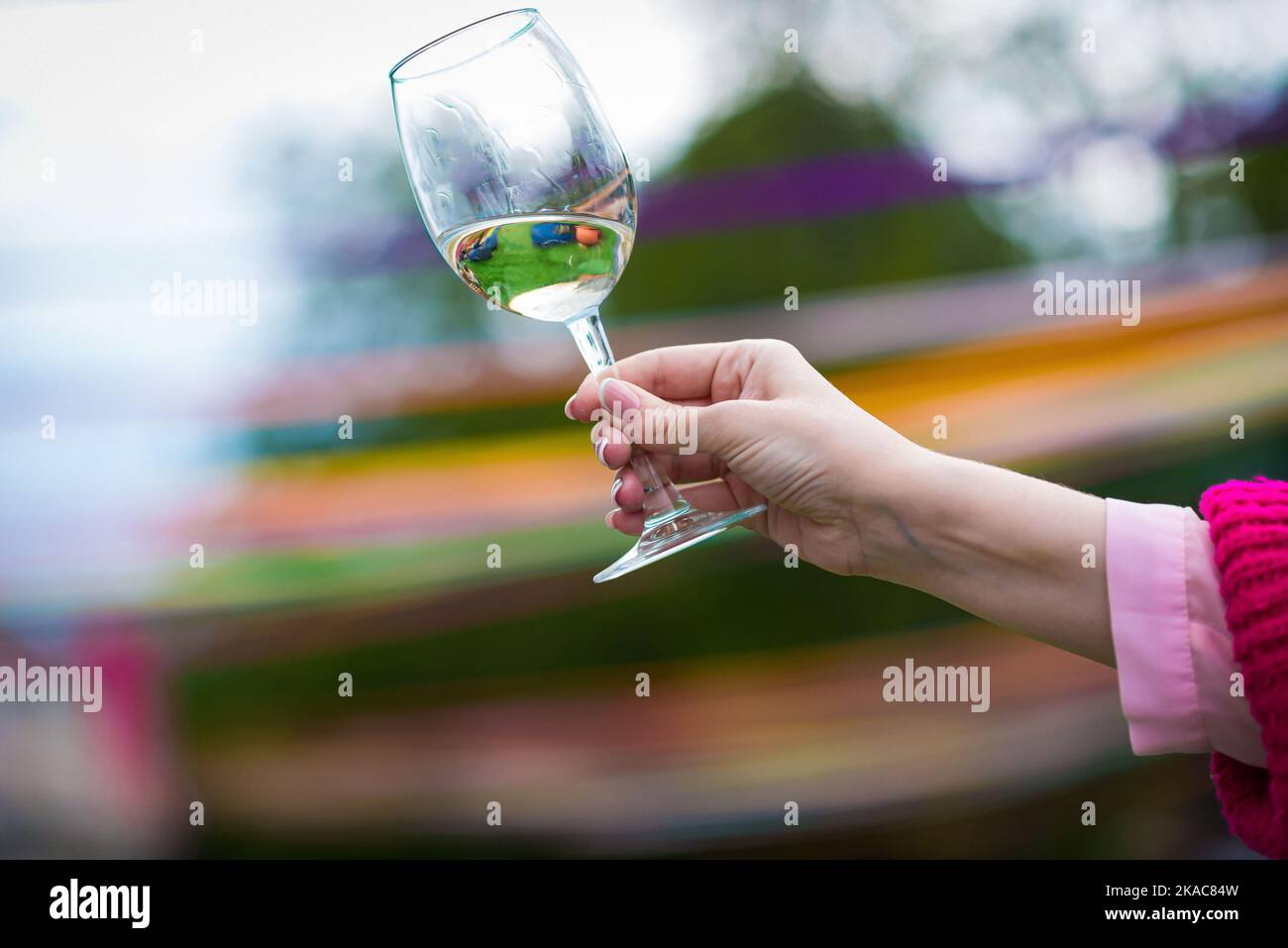 Menschen klirren Gläser mit Wein auf der Sommerterrasse des Cafés oder Restaurants, Glasflasche in den Händen verschiedenen Hintergründen Stockfoto