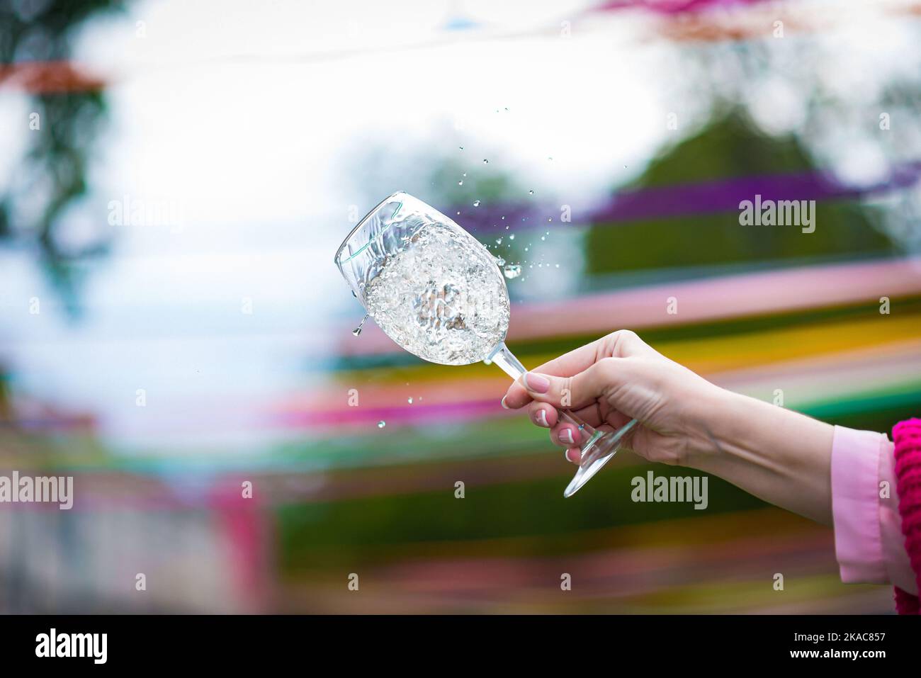 Menschen klirren Gläser mit Wein auf der Sommerterrasse des Cafés oder Restaurants, Glasflasche in den Händen verschiedenen Hintergründen Stockfoto