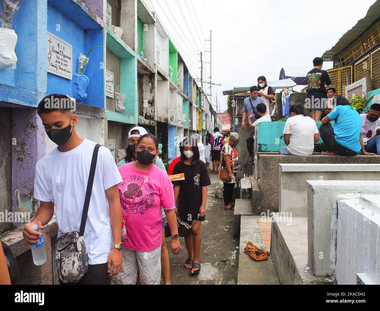 Caloocan City, Philippinen. 01.. November 2022. Friedhofsbesucher spazieren während des Allerheiligen-Tages durch enge Nischen. Filipinos strömen nach zwei Jahren der Covid-19-Pandemie auf Friedhofs, da sich die Einschränkungen langsam lockern. Die Tradition, Blumen zu bringen, Kerzen anzuzünden und sogar Nahrung an der Begräbnisstätte ihrer verstorbenen Lieben anzubieten. (Foto: Josefiel Rivera/SOPA Images/Sipa USA) Quelle: SIPA USA/Alamy Live News Stockfoto