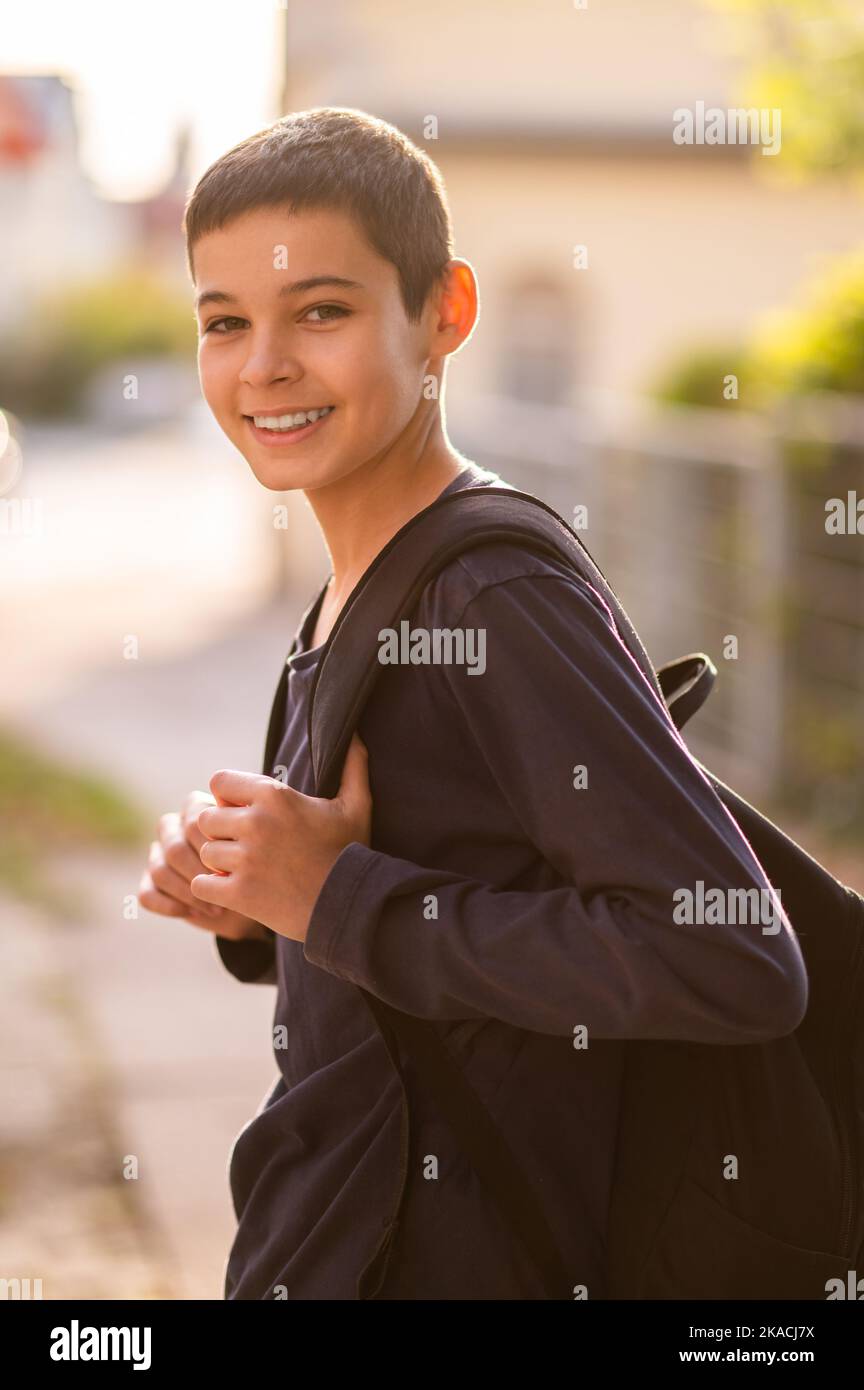 Fröhlicher Jugendlicher mit Rucksack im Freien Stockfoto