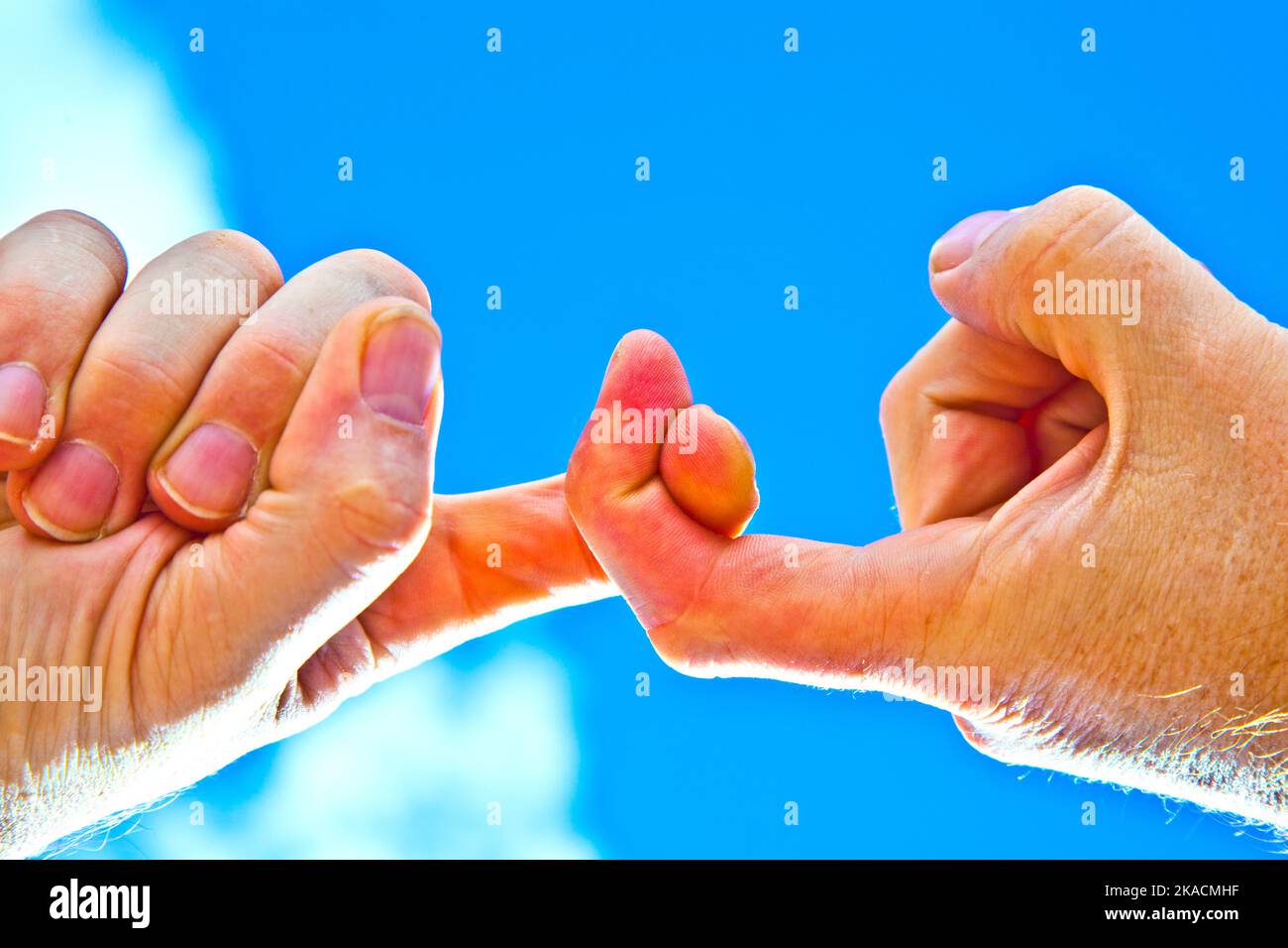 Zwei Finger sind mit dem blauen Himmel verbunden Stockfoto