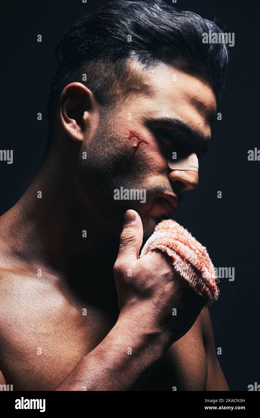 Verletzung, Blut und Mann mit einem Verband aus Kämpfen oder Training für MMA oder Kickboxen in einem dunklen Studio. Gewalt, verletzt und Guy Boxer aus Mexiko nach Stockfoto