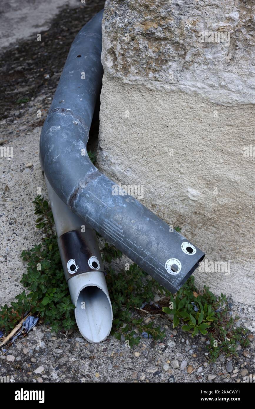 Witzige oder amüsante, schlange Rinnen oder Downpipes, die mit Stick on Eyes verziert sind Stockfoto