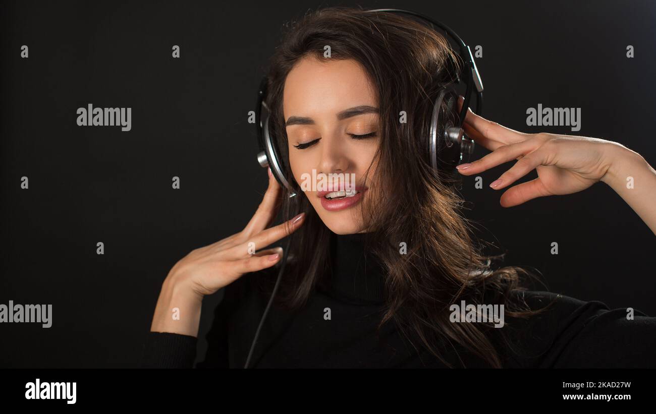 Nahaufnahme eines Porträts einer jungen Frau, die beruhigende Musik über Kopfhörer hört. Sie schließt die Augen und genießt die Musik. Stockfoto