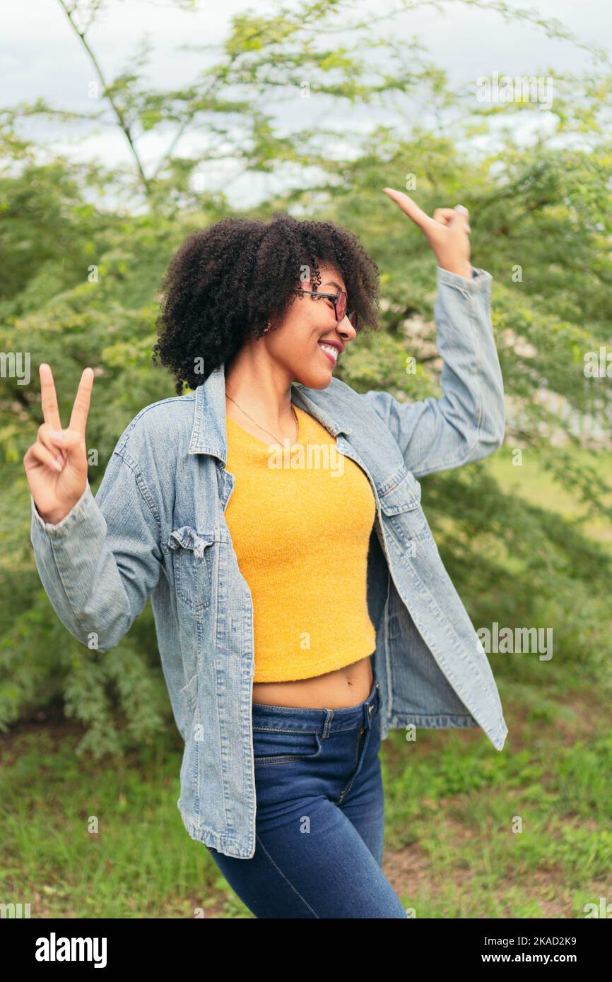 Lateinische Frau, die im Freien auf einem natürlichen grünen Hintergrund tanzt. Stockfoto