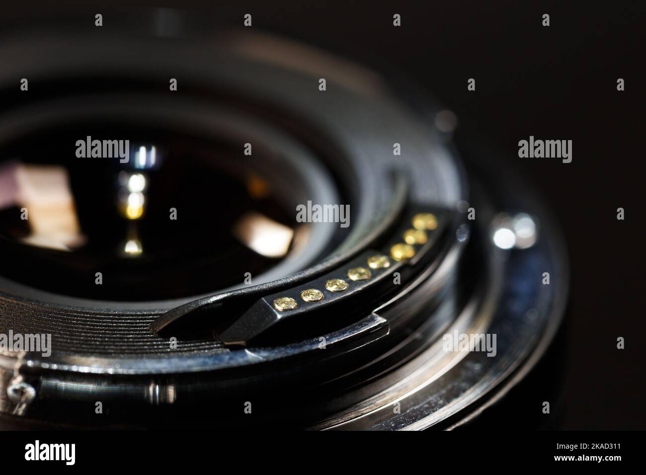Die Rückseite eines modernen Objektivs mit Kontakten am Bajonett. Makrofotografie vor einem dunklen Hintergrund mit geringer Schärfentiefe Stockfoto