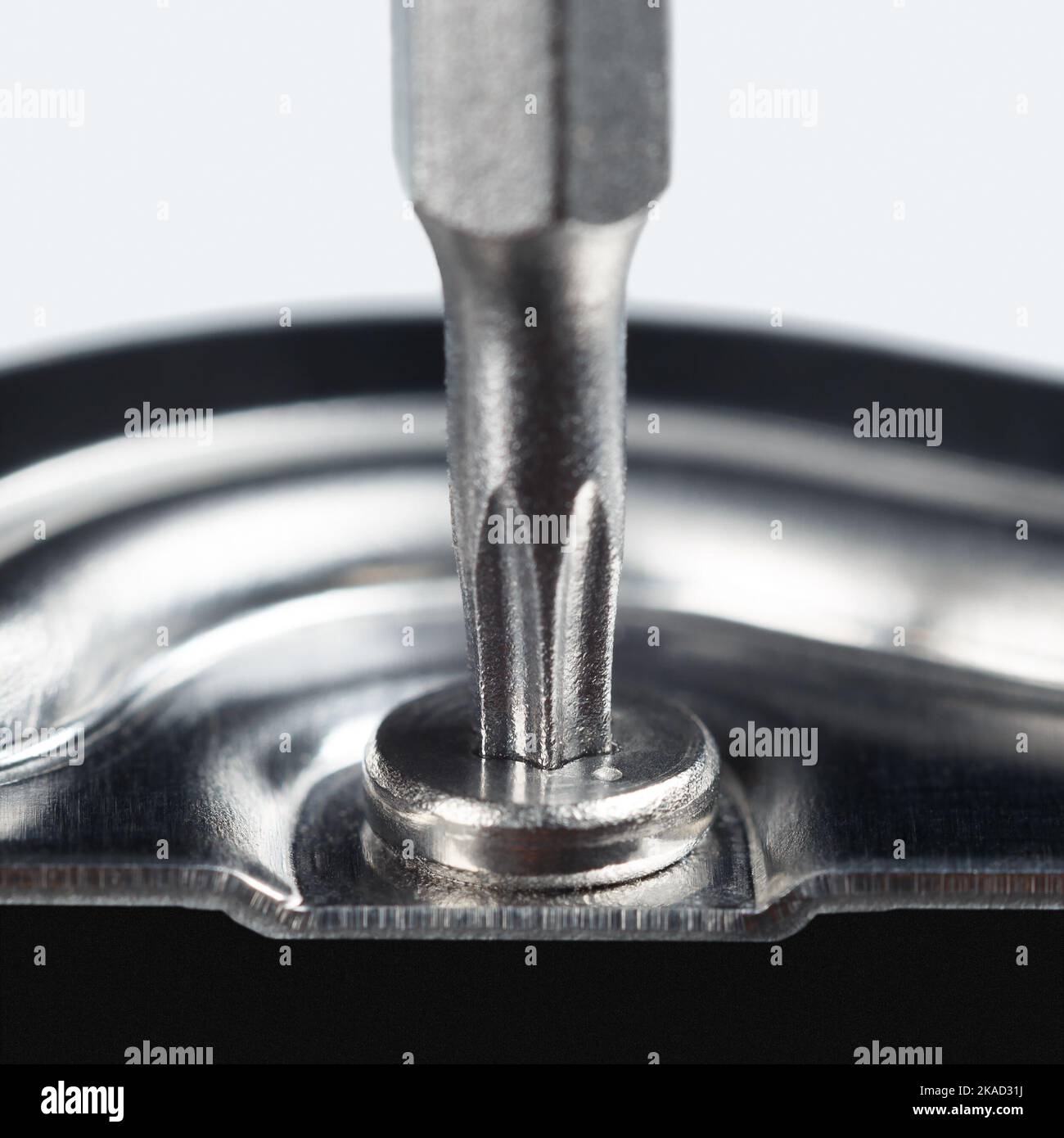 In die Schraube wird ein Schraubendreher mit einem Sternchen eingesetzt. Makrofotografie. Stockfoto