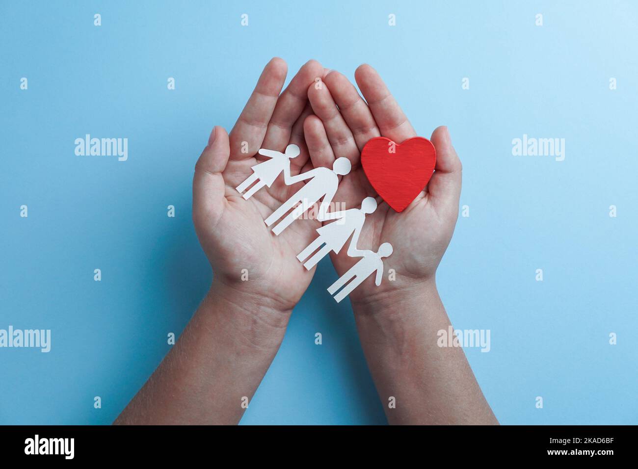 Hände mit Papier Familienausschnitt, Lebensversicherung, soziales Distanzierungskonzept, covid19, auf blauem Hintergrund, Familienschutz Stockfoto