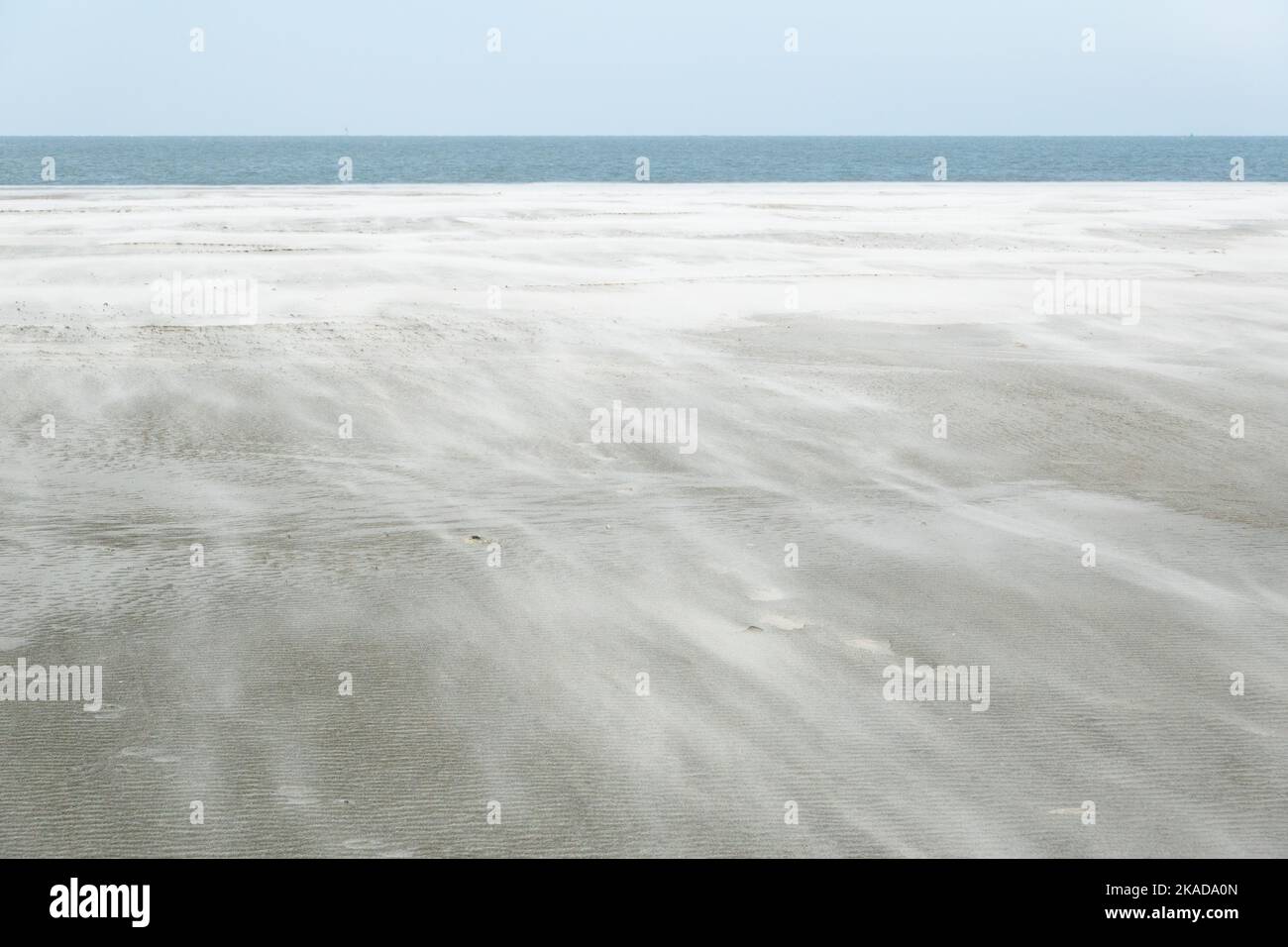 Sturm weht Sand über weiten Strand Stockfoto