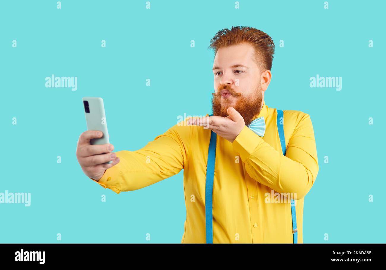 Lustige mollige Mann verliebt nimmt Selfie auf Handy und bläst Luftkuss für seine Freundin Stockfoto