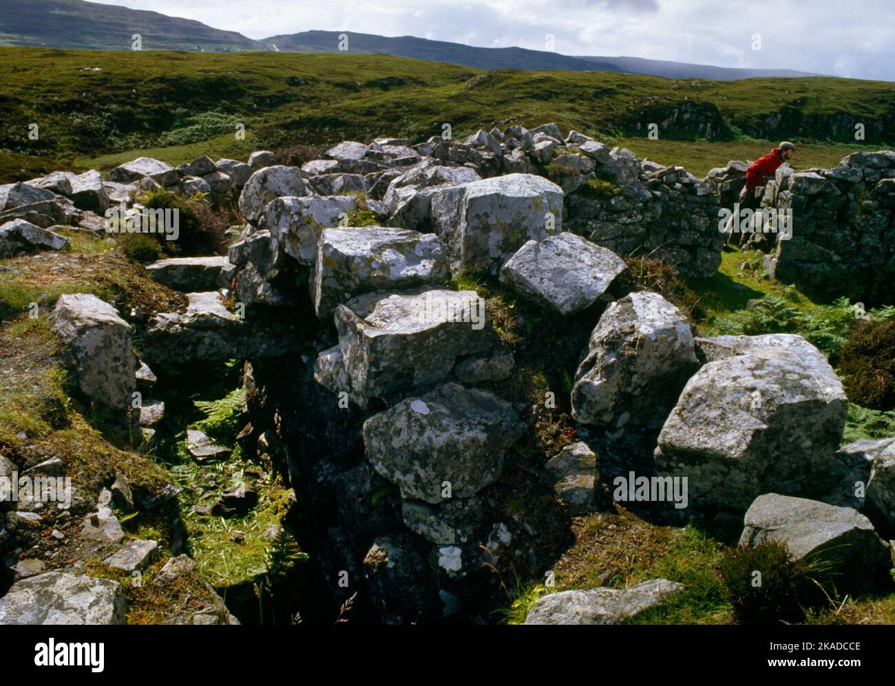 Dun Fiadhairt Iron Age Broch, Isle of Skye, Schottland, Großbritannien, blickt W entlang der S-Wandgemälde-Galerie zum Haupteingang von W mit einer erwachsenen männlichen Figur Stockfoto