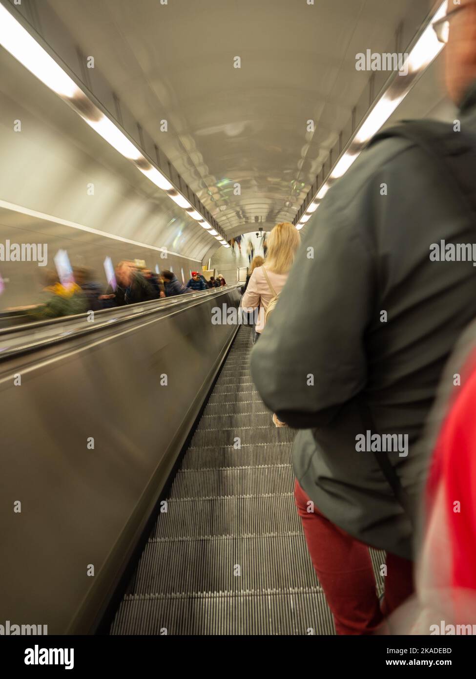 Rolltreppe in der U-Bahn mit Menschen außerhalb des Fokus Stockfoto