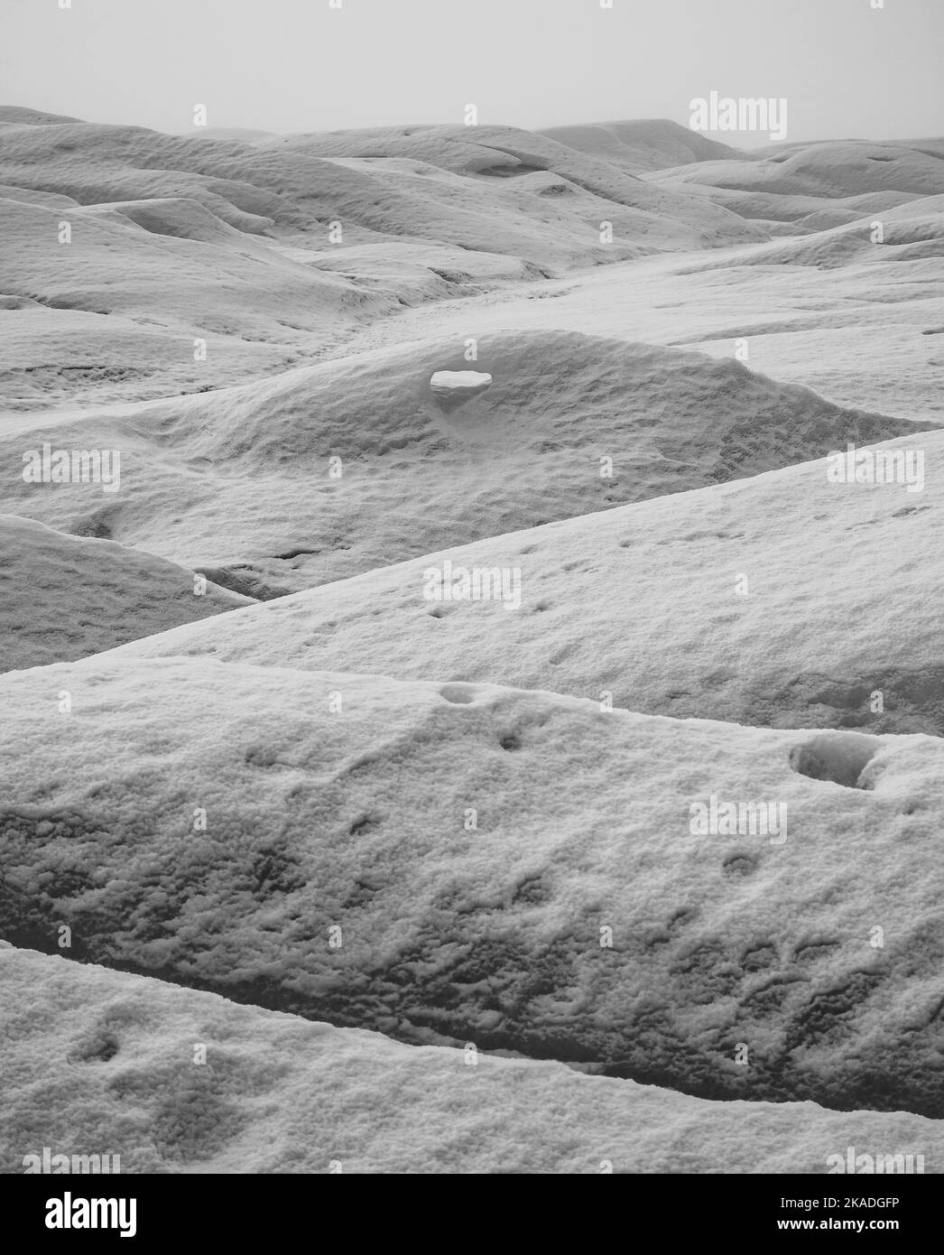 Eine vertikale Graustufenaufnahme von strukturiertem Schnee auf einem Berg in El Calafate, Argentinien Stockfoto