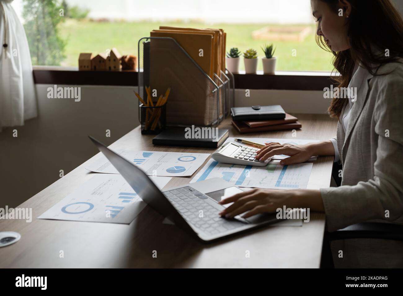 Geschäftsfrau, die mit einem Rechner arbeitet, um die Zahlen zu berechnen. Konzept der Finanzbuchhaltung Stockfoto