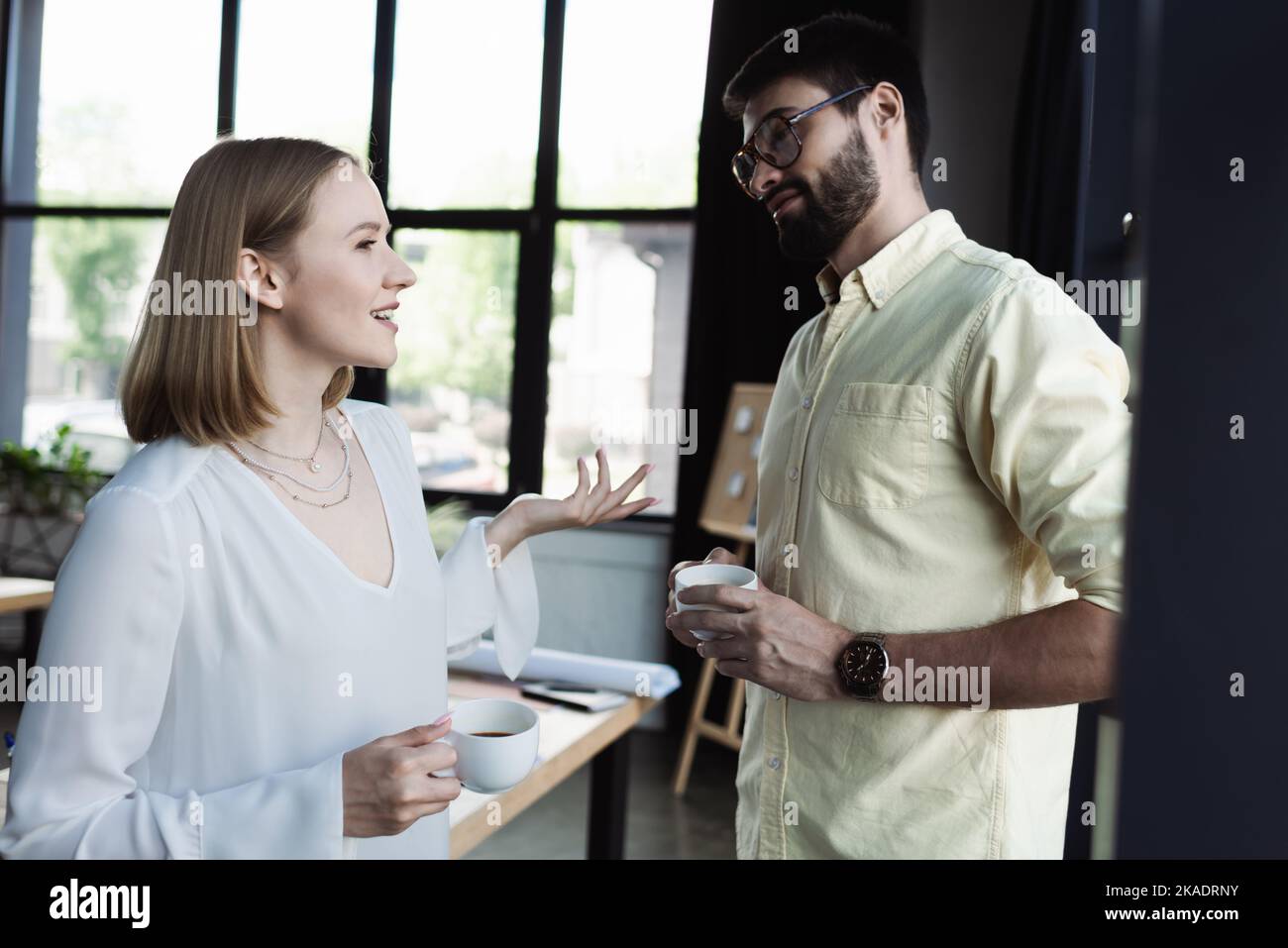 Neuer Mitarbeiter mit einer Tasse Kaffee im Gespräch mit dem Manager im Büro, Bild auf Lager Stockfoto