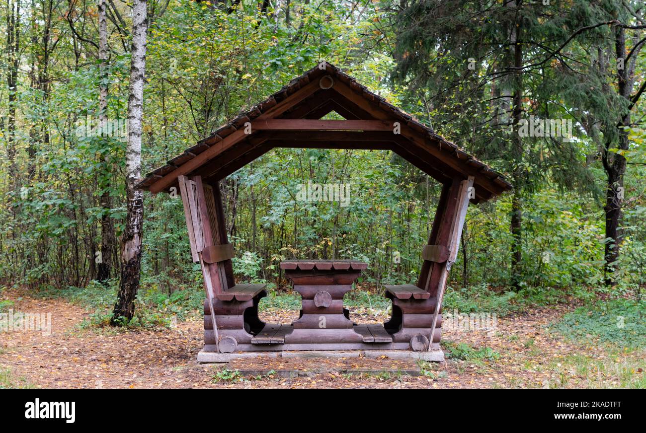 Kleines Holzpicknickhaus im Herbstwald vor dem Hintergrund der fallenden gelben Blätter im Wald Stockfoto