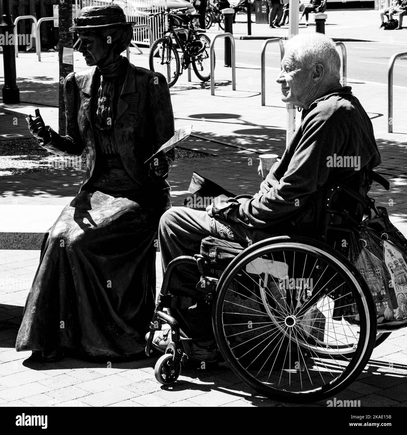Epsom Surrey, London, Großbritannien, Juni 01 2022, Alter oder älterer Mann mit Behinderung, der auf Einem Rollstuhl neben Einer Statue auf der Town Center High Street sitzt Stockfoto
