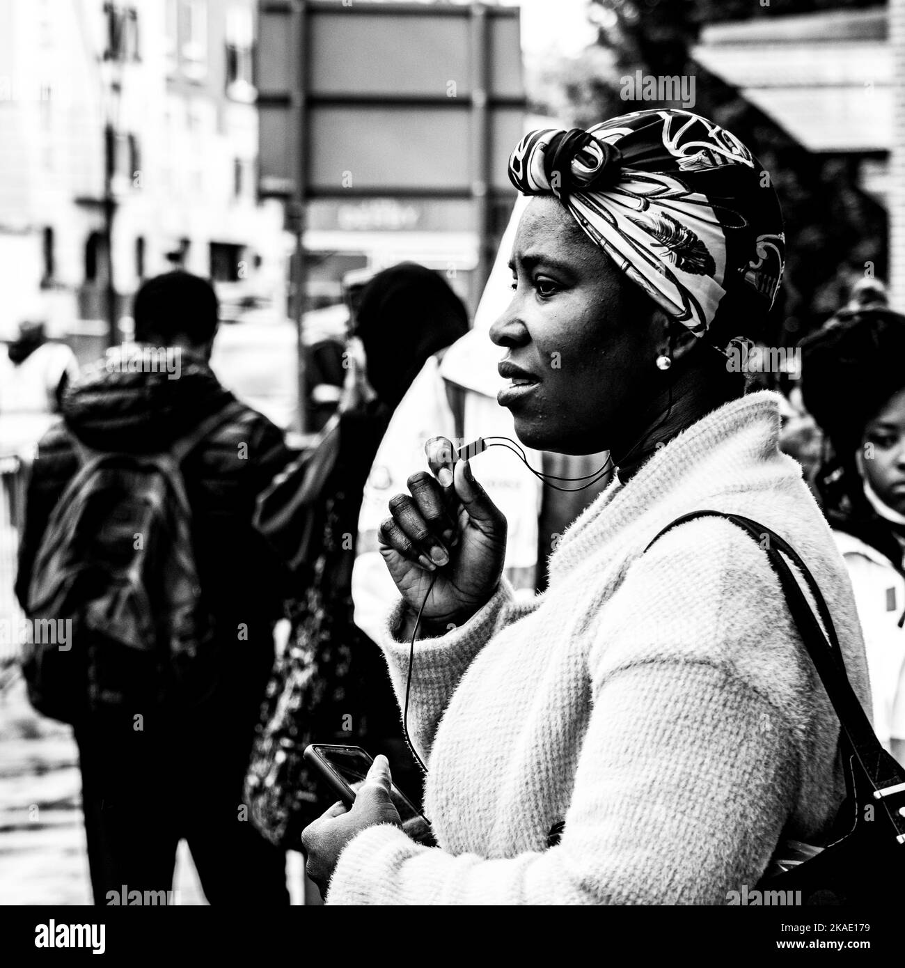 Epsom Surrey, London, Großbritannien, Juni 04 2022, Nachdenkliche Schwarze Frau, die allein mit dem Mobiltelefon steht Stockfoto