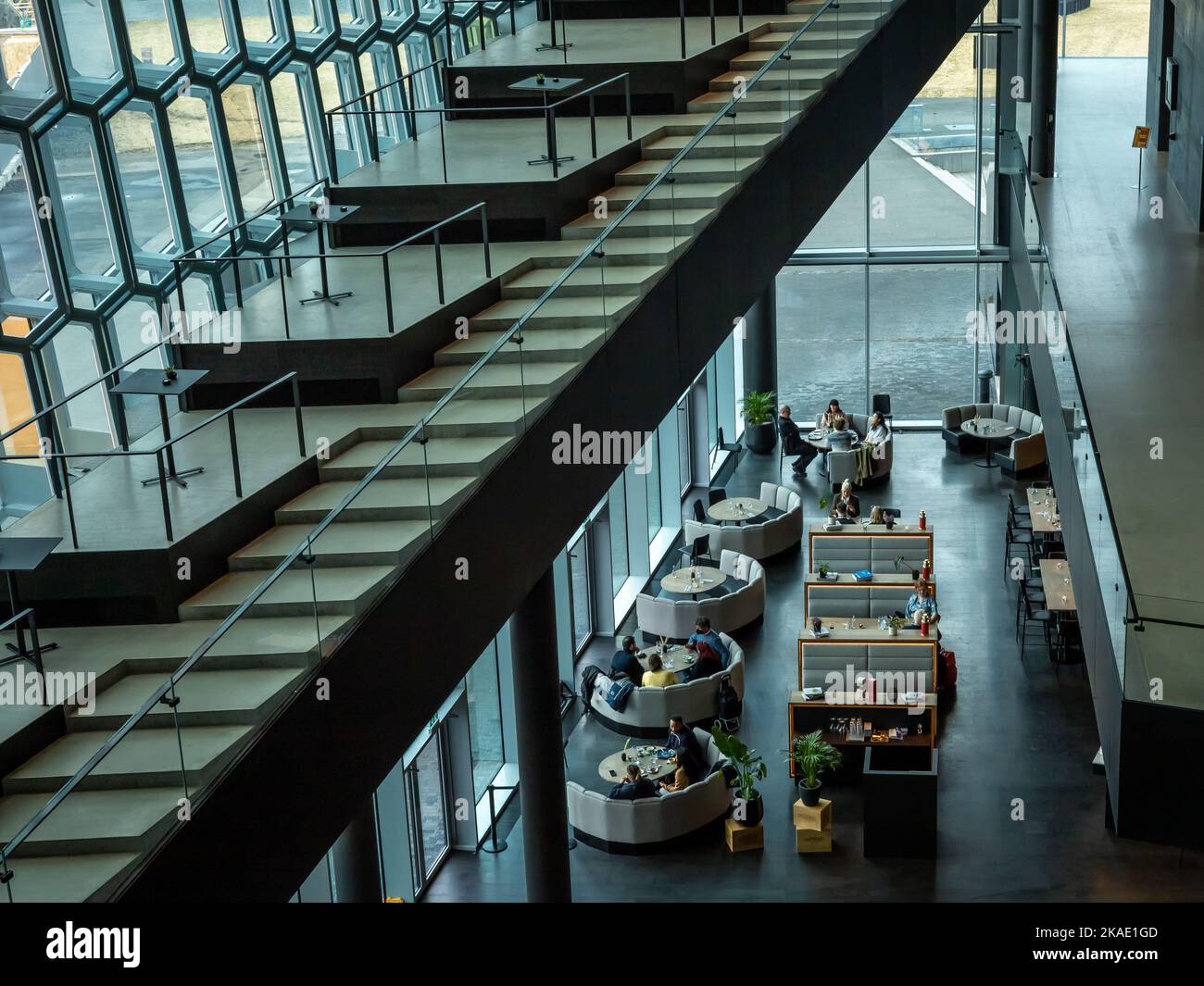 Reykjavik, Island - 23. März 2022: Gäste im Restaurant im Konzertsaal Harpa. Moderne Architektur, farbenfrohe Glaswände. Stockfoto