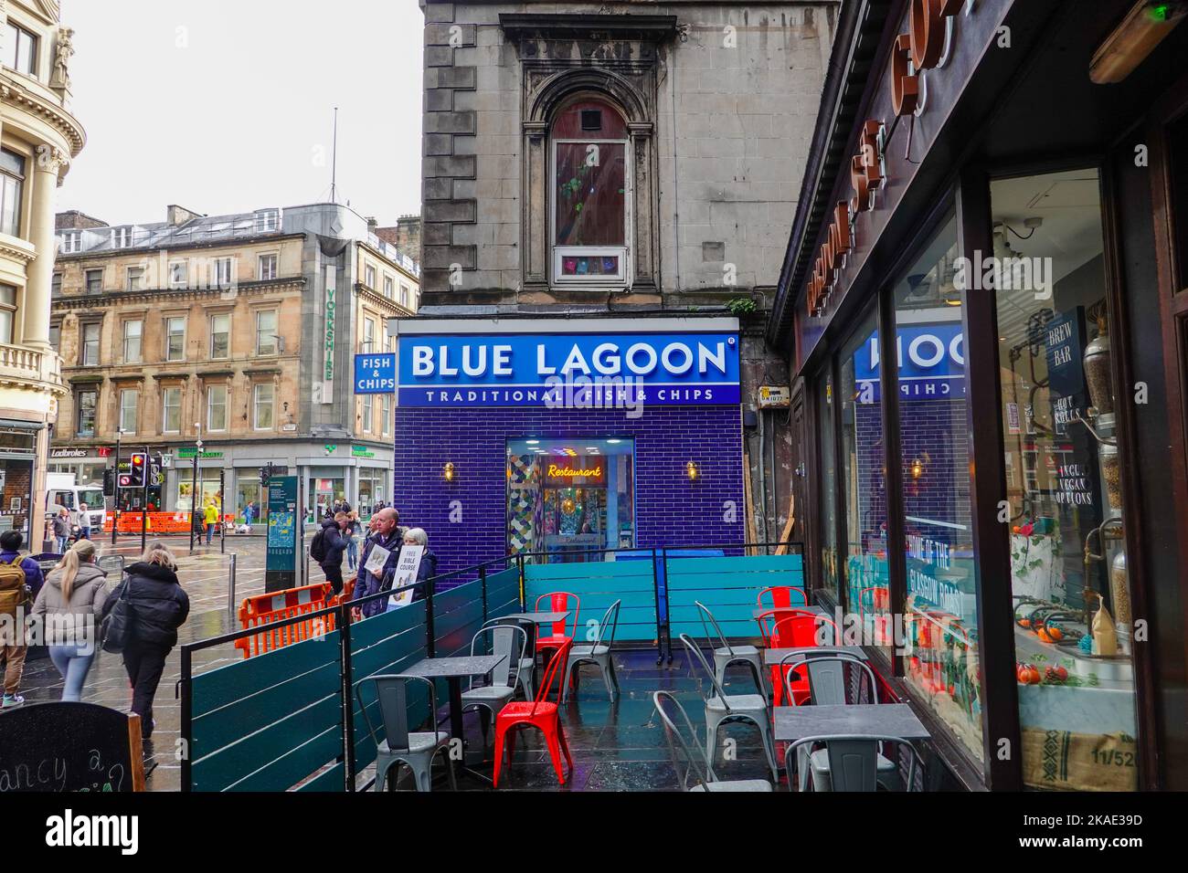 Straßenszene, Blue Lagoon Fish & Chips, auf der Gordon Street, außerhalb des Hauptbahnhofs mit Menschen, die bei leichtem Regen stehen, Glasgow, Schottland. Stockfoto