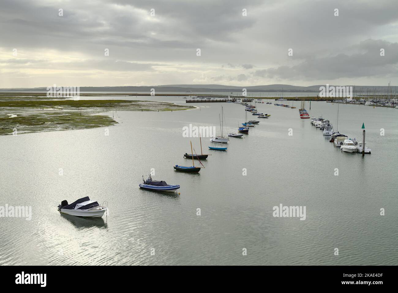 Verankerte Boote am Eingang des Lymington River mit Blick über den Solent nach Yarmouth und die Isle of Wight, Lymington, Großbritannien Stockfoto