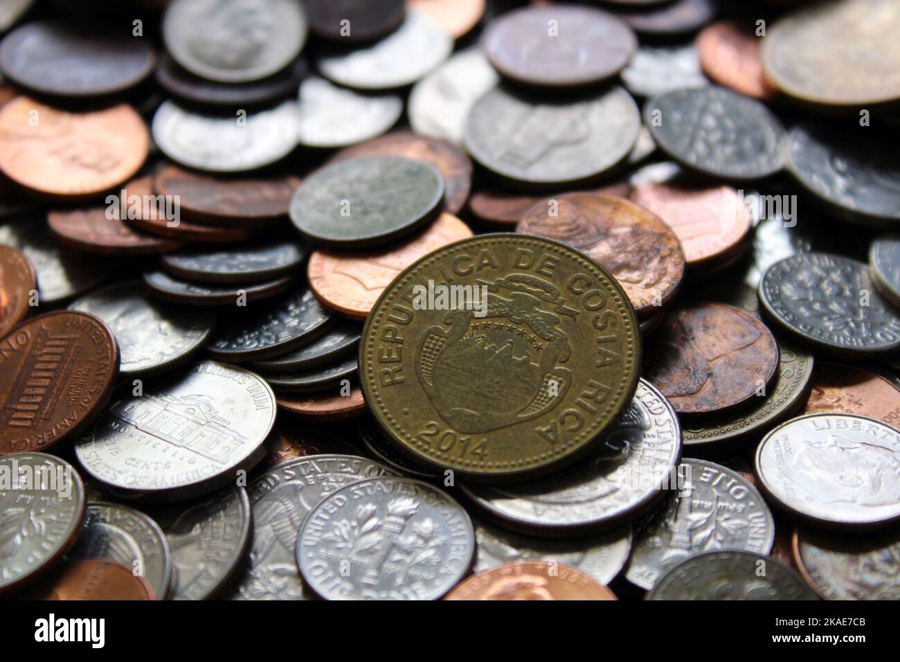 Eine Nahaufnahme der costaricanischen Währung Colones Münze mit amerikanischen Vereinigten Staaten Münzgeld im Hintergrund Stockfoto