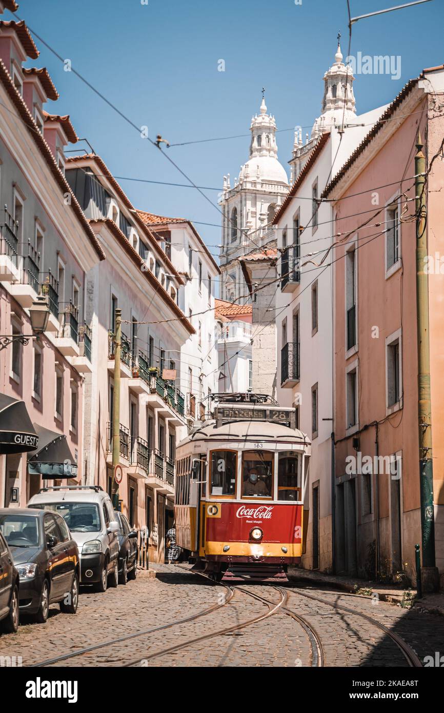 Eine vertikale Aufnahme einer Straßenbahn mit CocaCola-Werbung auf der Straßenbahn in den sonnigen gepflasterten Straßen von Lissabon, Portugal Stockfoto