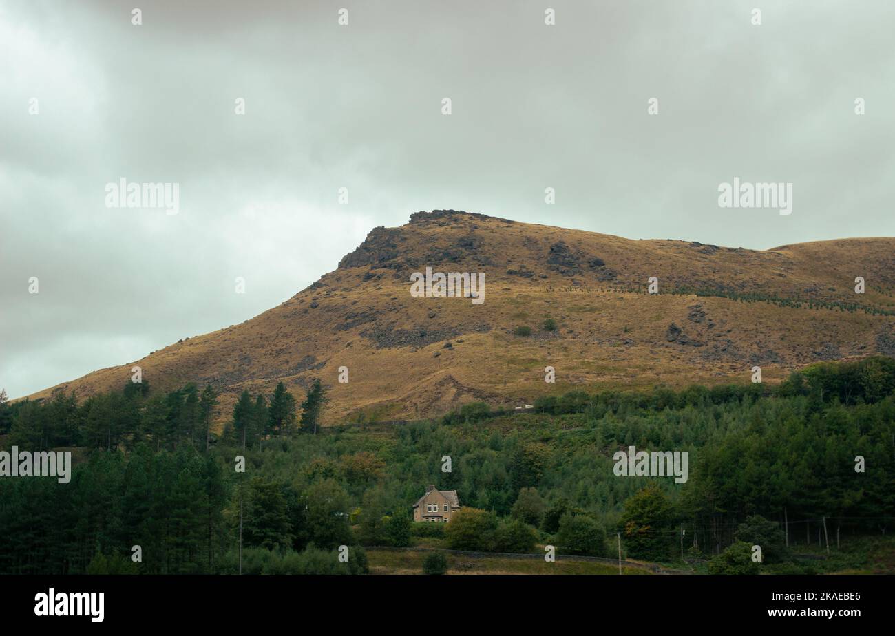 Ein Hügel, der über einem einzigen Haus in England thront. Stockfoto