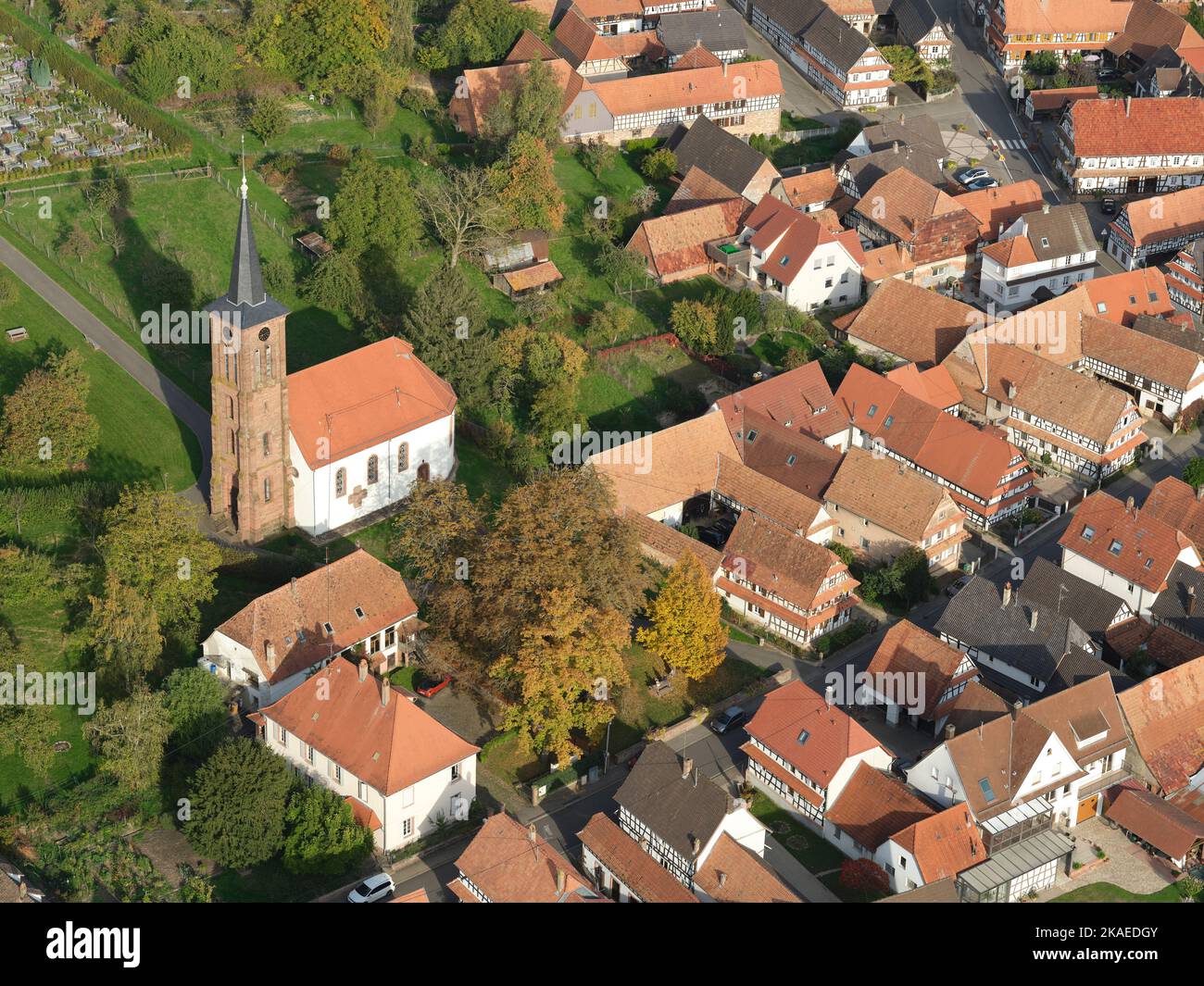 LUFTAUFNAHME. Evangelische Kirche mit Blick auf die Rue Principale und ihren einzigartigen Fachwerkhäusern. Hunspach, Bas-Rhin, Elsass, Grand Est, Frankreich. Stockfoto