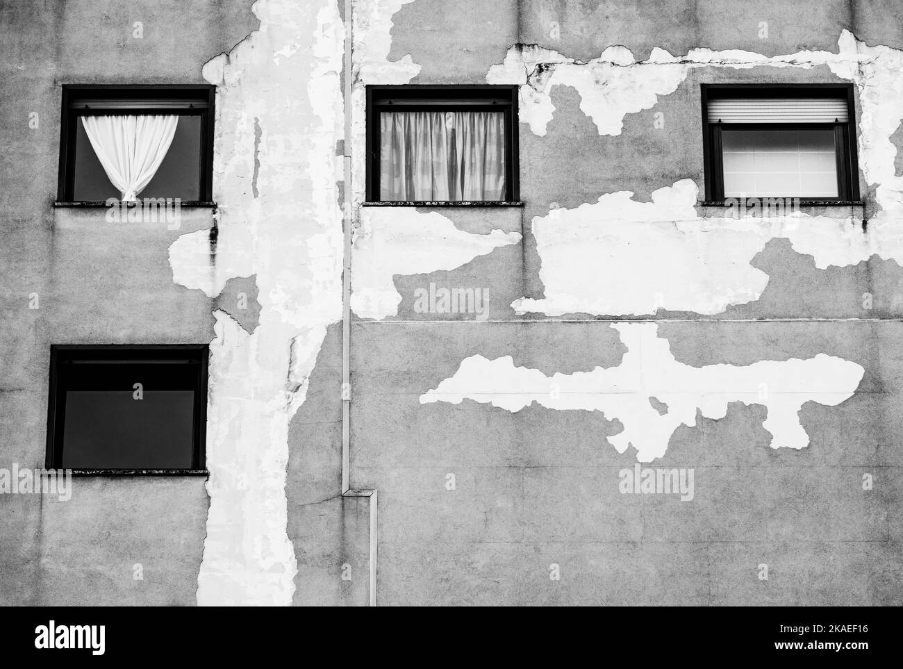 Wndows mit Vorhang auf der zerstörten Fassade des Gebäudes Stockfoto