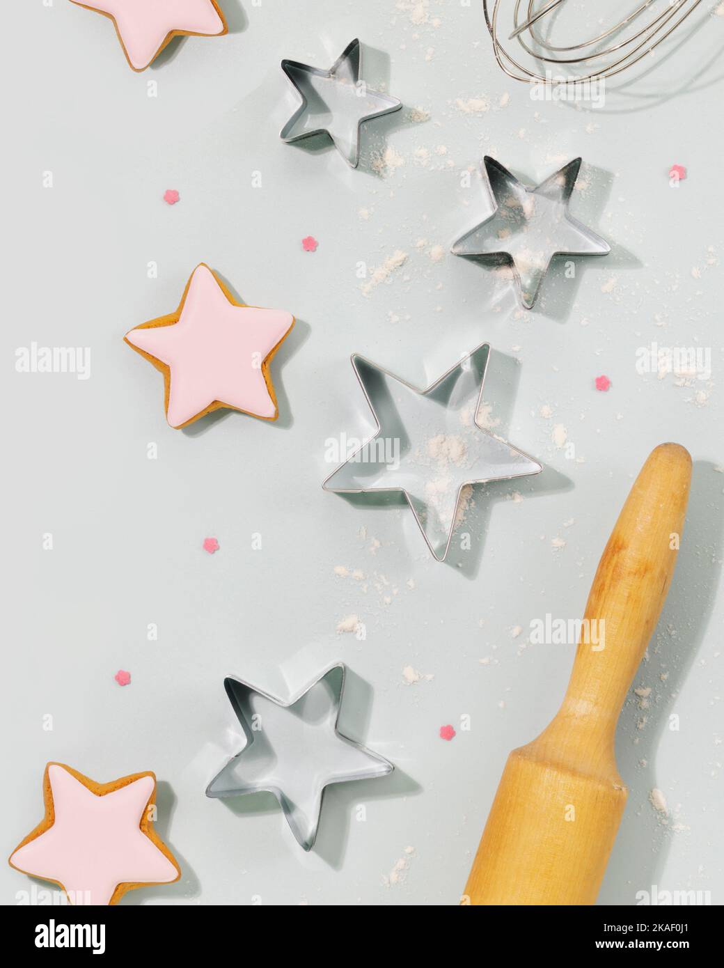 Wir kochen Urlaubseks. Bäckerei Kind flach lag. Ingwerkekse in Form von Sternen, bedeckt mit Glasur, Ausstechformen, einer Teigliege und einem Schneebesen auf einem Stockfoto