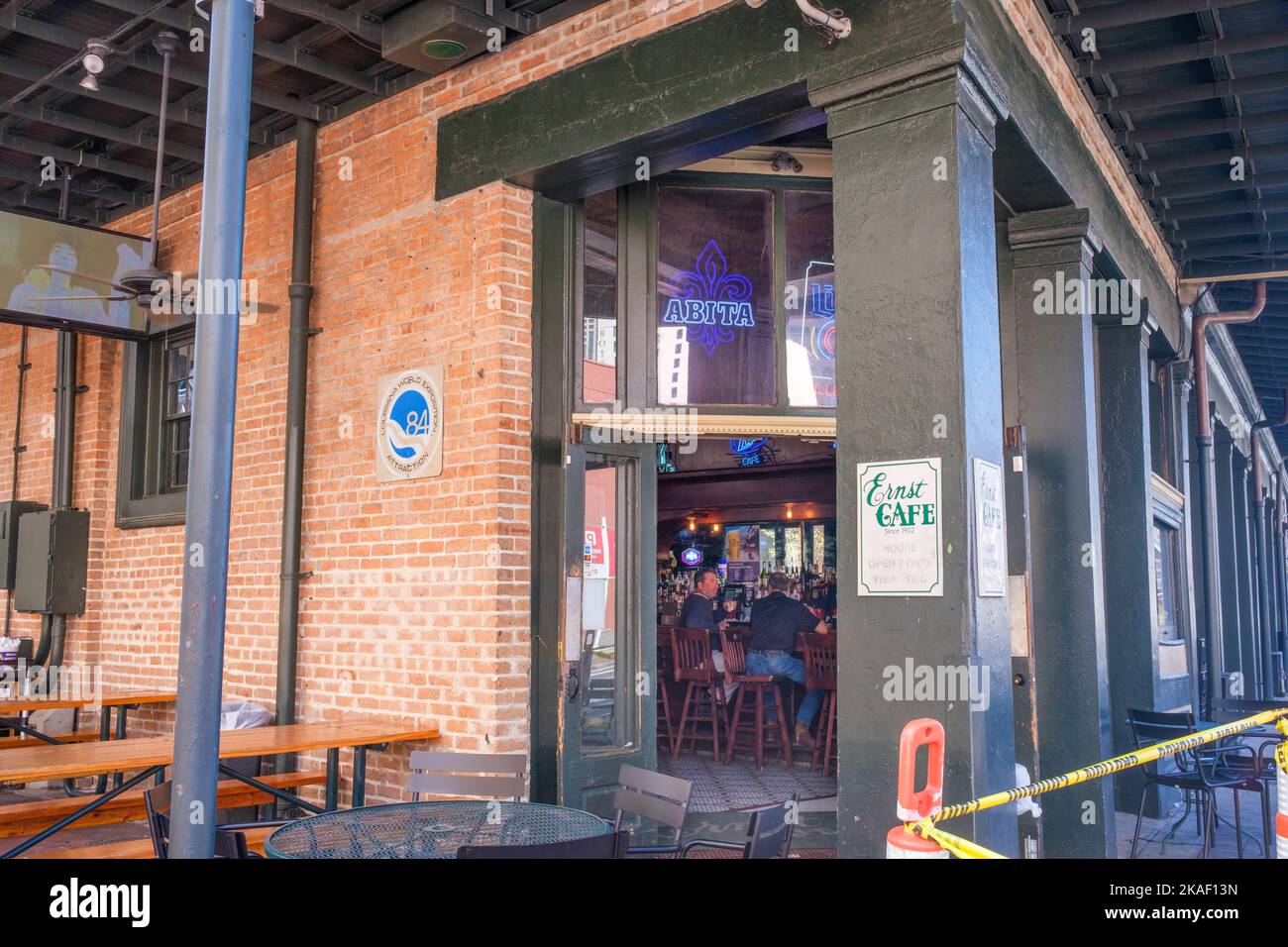 NEW ORLEANS, LA, USA - 26. OKTOBER 2022: Eingang und offene Eingangstür mit zwei Männern an der Bar im Ernst Cafe im Warehouse District Stockfoto