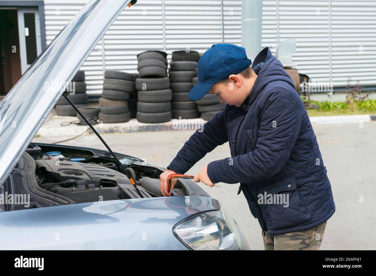 Auszubildender Automechaniker arbeitet in einer Garage, im Freien. Kfz-Reparaturservice-Konzept Stockfoto