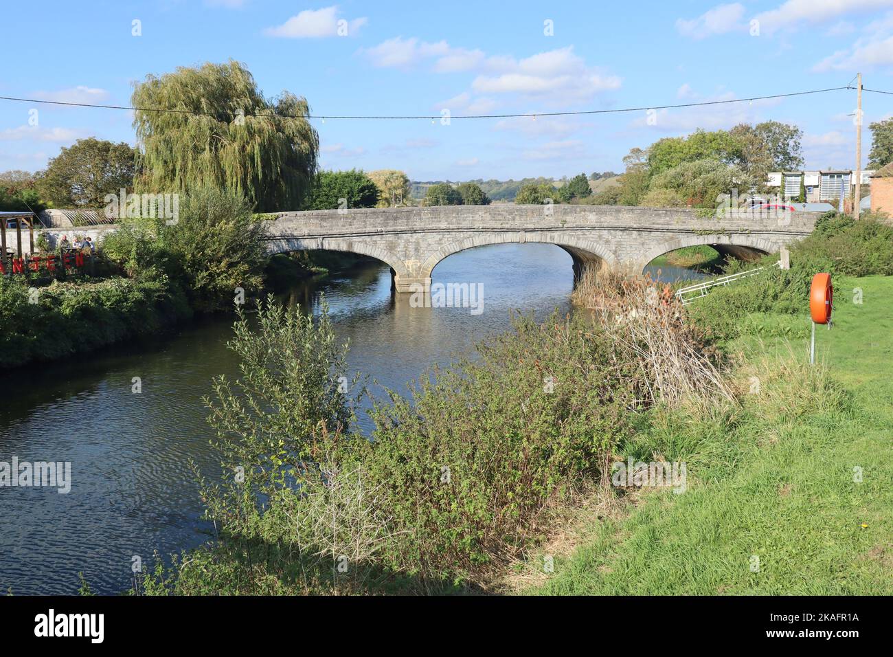 Eine steinerne Dreibogenbrücke über den Fluss Parrett in Langport, Somerset, während sie durch den öffentlichen Park fließt Stockfoto