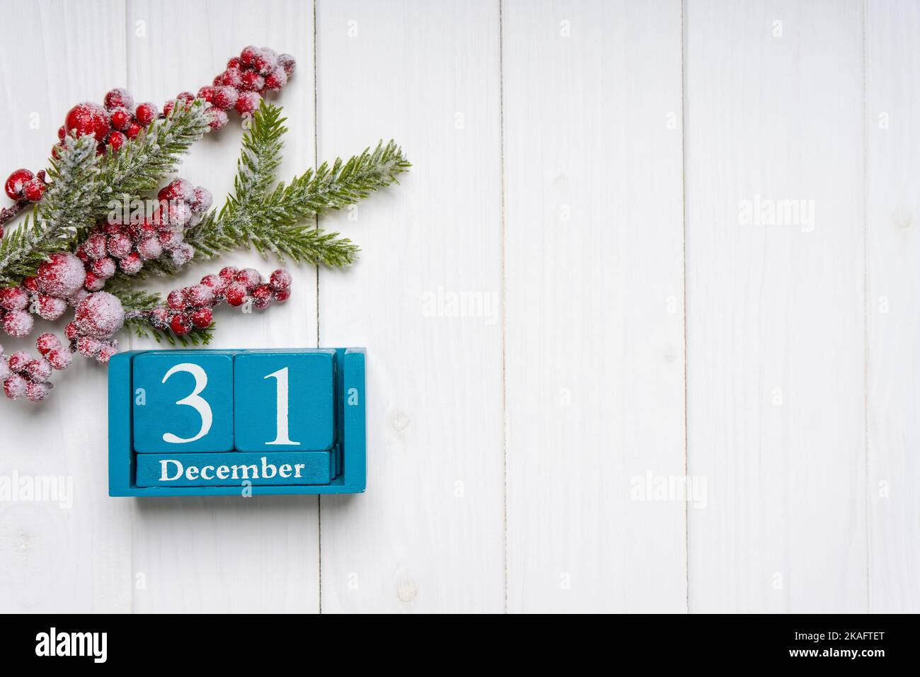 Christbaumzweig mit Dekor und blauem ewigen Kalender auf weißem Holzhintergrund. Draufsicht, Flat Lay mit Kopierplatz, Banner, Kopfzeile, Neujahr Stockfoto
