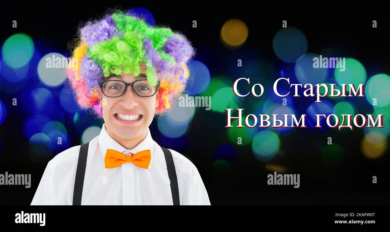 Porträt eines fröhlichen jungen Weißen mit bunter Perücke vom russisch-orthodoxen Neujahrstext Stockfoto