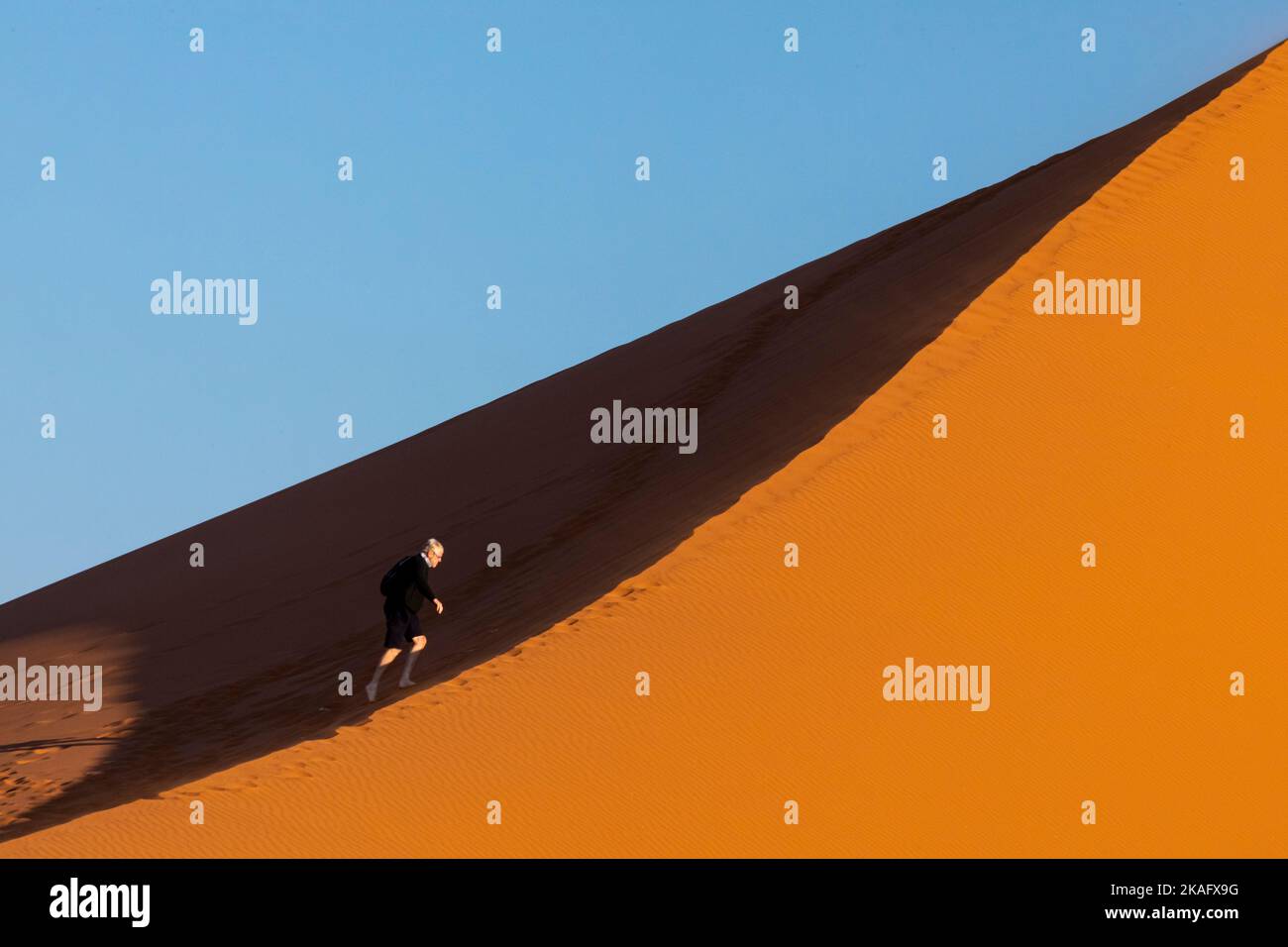 Eine Person wandert durch die Sanddünen der Namib Wüste, Namibia Stockfoto