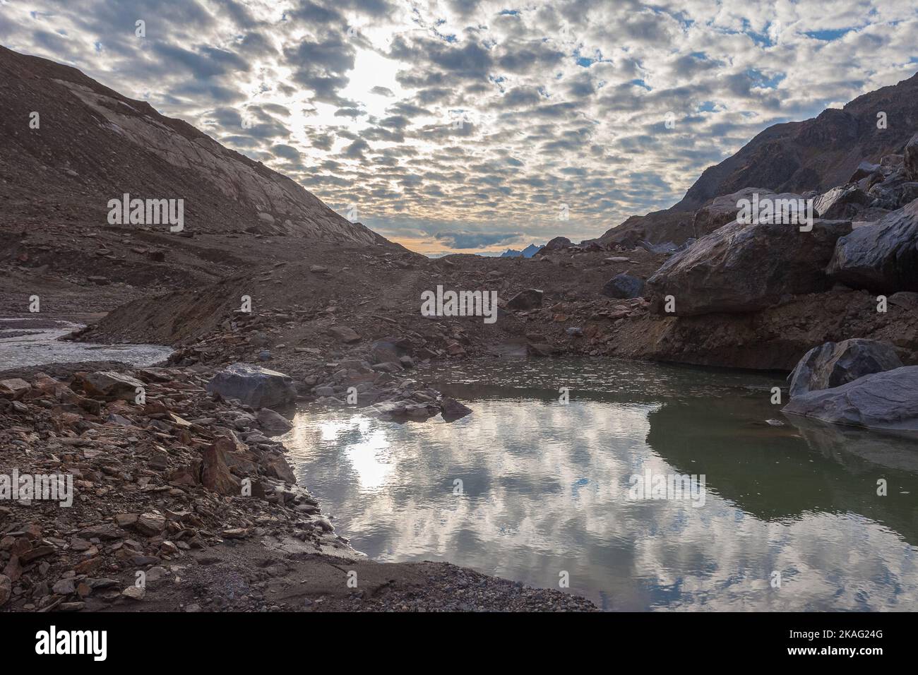 Kleiner See und Bach, erzeugt durch den Gletscher des Vallelungagletschers, der bei Sonnenuntergang schmilzt Stockfoto