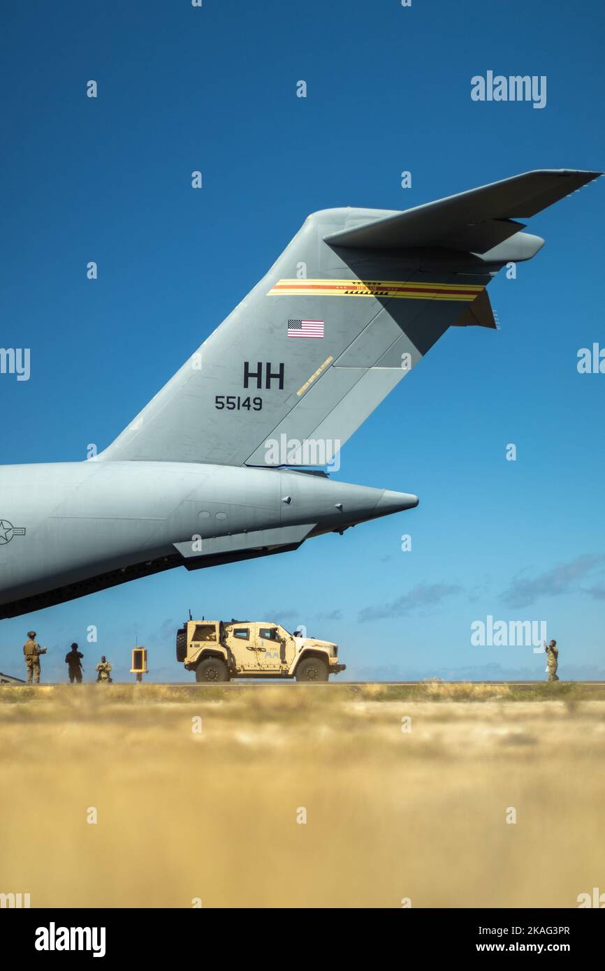 Ein US Marine Corps Joint Light Tactical Vehicle bereitet sich darauf vor, während der Übung Bougainville II in der Pacific Missile Range Facility, Barking Sands, Hawaii, 31. Oktober 2022, auf einen an 15. Wing angeschlossenen Globemaster III der US Air Force C-17 zu laden. 3D Marine Littoral Regiment Verbot eine feinde maritime Oberflächenplattform, um Bedingungen für gemeinsame Truppe zu schaffen, die Maßnahmen ergreifen soll. BVII ist eine Feldübung, die es dem MLR und seinen untergeordneten Einheiten ermöglicht, Expeditions- und Basisoperationen auf der Insel Oahu durchzuführen. BVII zeigt die Fähigkeit des MLR, eABS schnell zu etablieren und zu verdrängen, während er excuti Stockfoto